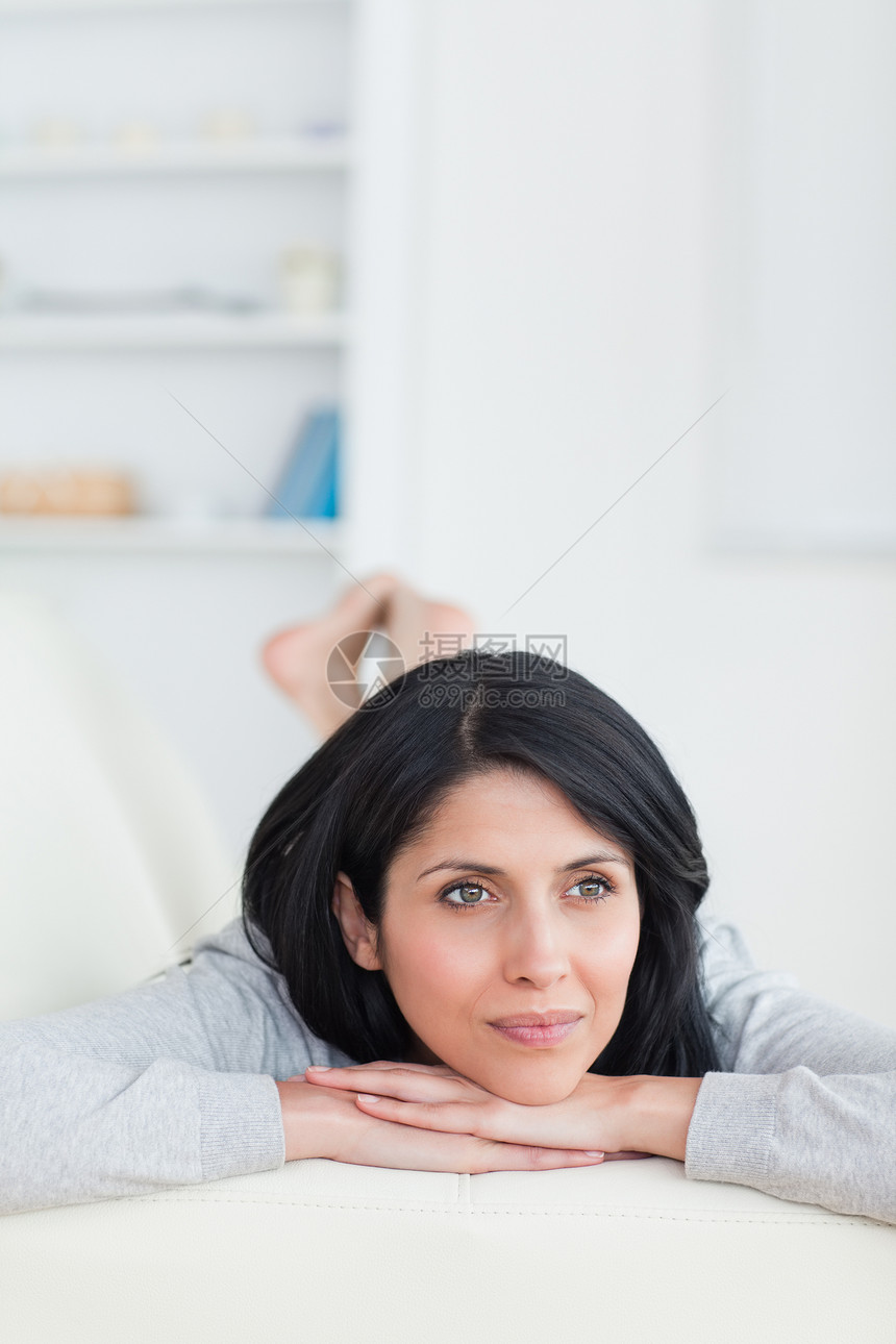 女人在沙发上躺着 同时抬着头头发长椅女性棕色花朵长发窗户客厅女士图片