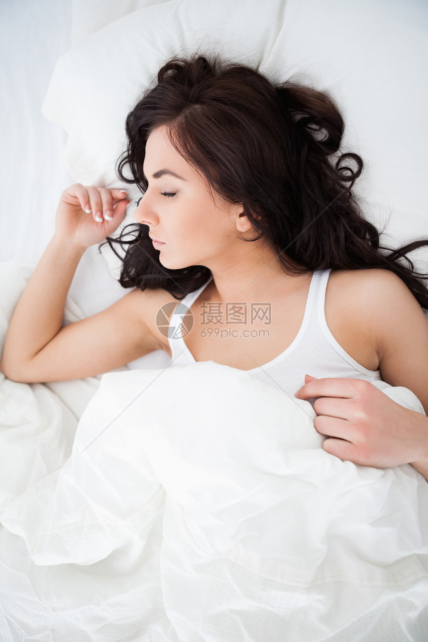 黑发女人睡着时躺在被子下图片