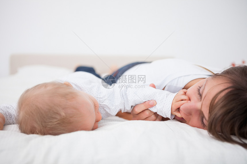 可爱的婴儿把她的手放在母亲的嘴上图片