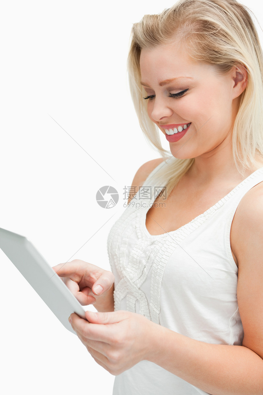 金发女人在使用平板电脑时站立图片