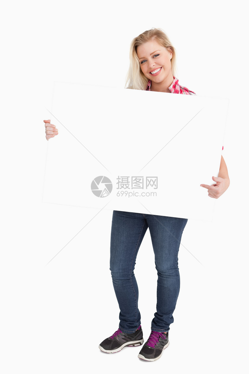 金发女人在指着标牌时闪烁图片