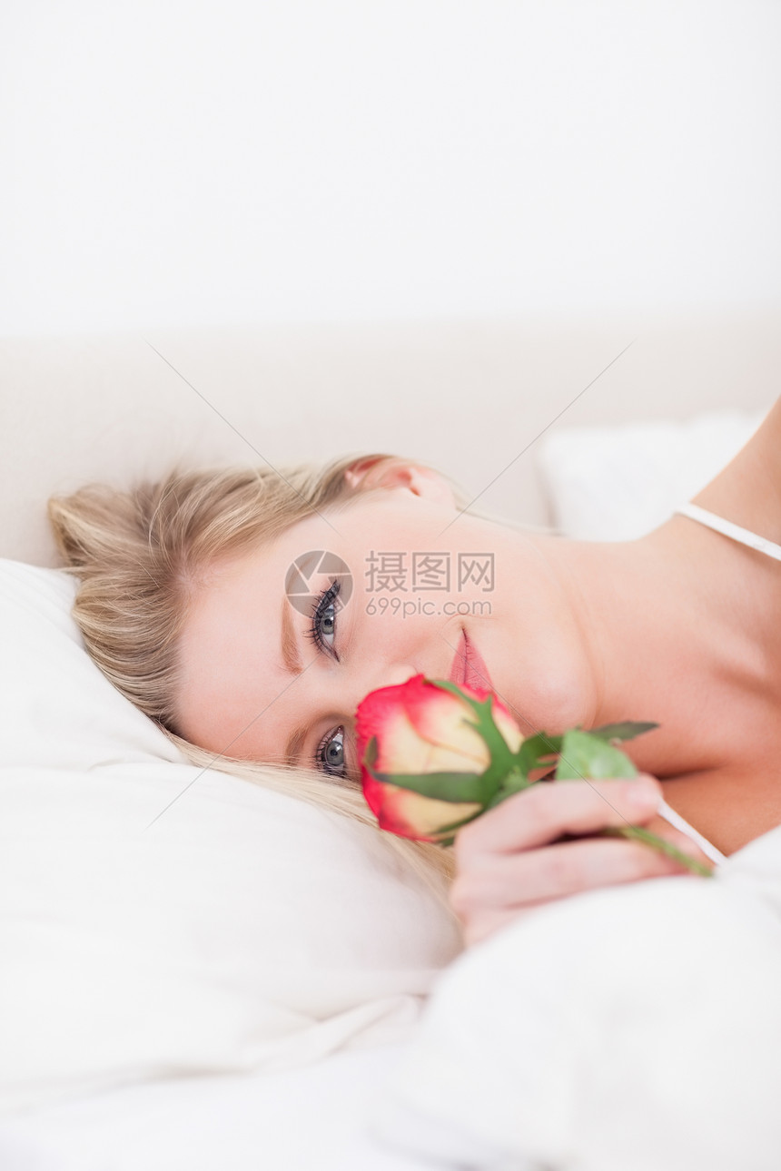 蓝眼女人闻着玫瑰的香味图片