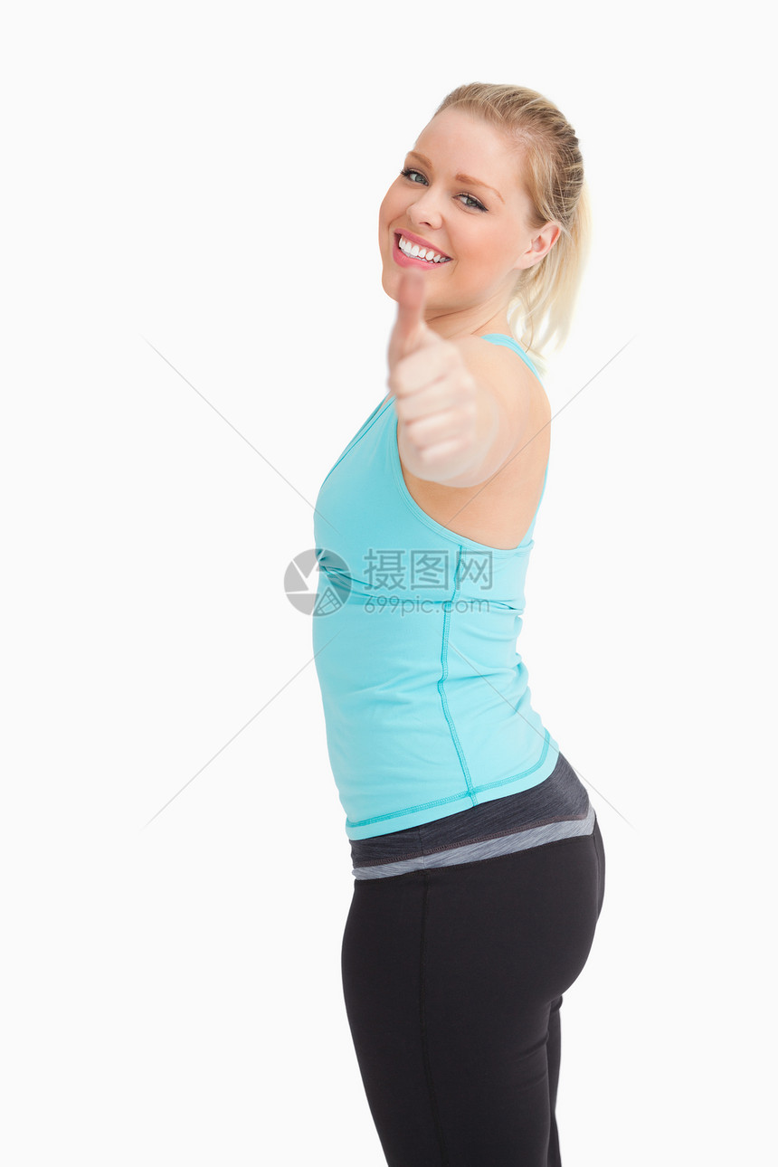 举起大拇指的女人女性运动服头发运动浅色营养手臂女士蓝色金发女郎图片