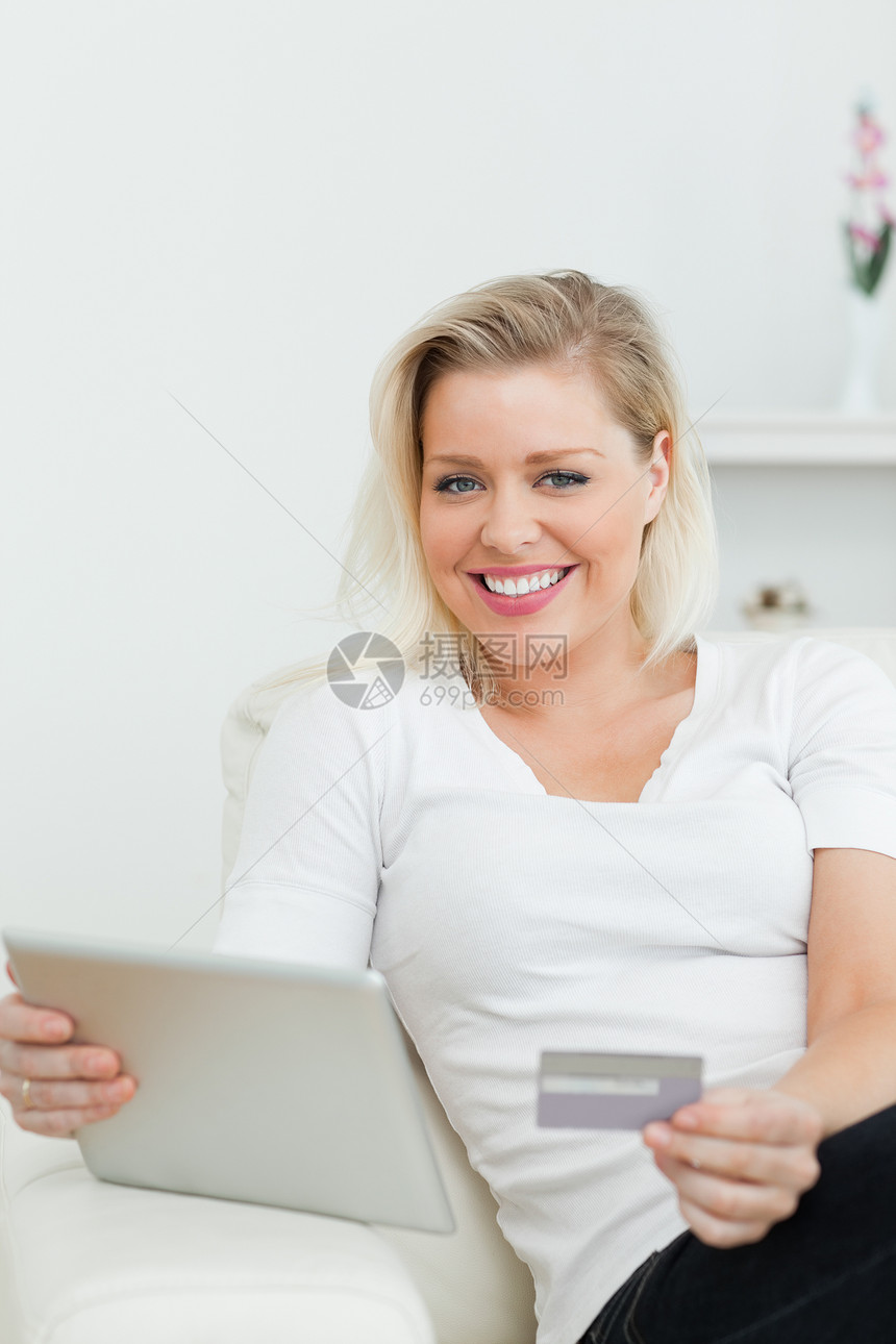 持信用卡和平板电脑的妇女图片