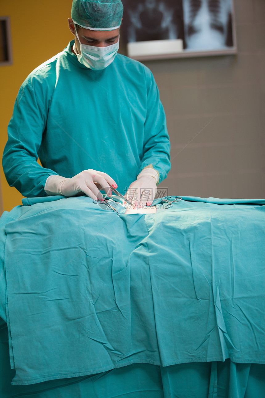 手术病人的外科医生临床男人医疗制服医院磨砂膏口罩手套手术帽卫生图片