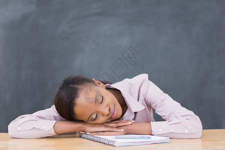 黑女人闭着眼睛把头靠在桌子上背景图片