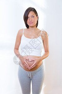 美丽的孕妇爱心形符号的美丽孕妇婴儿身体幸福家庭女性母性肚子女孩生活怀孕背景图片