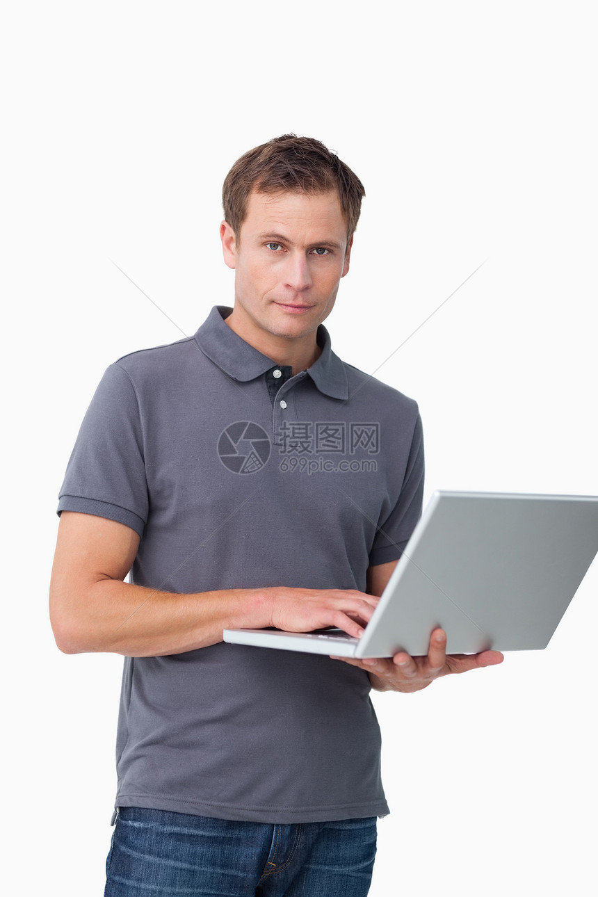 年轻人拿着笔记本电脑站着图片