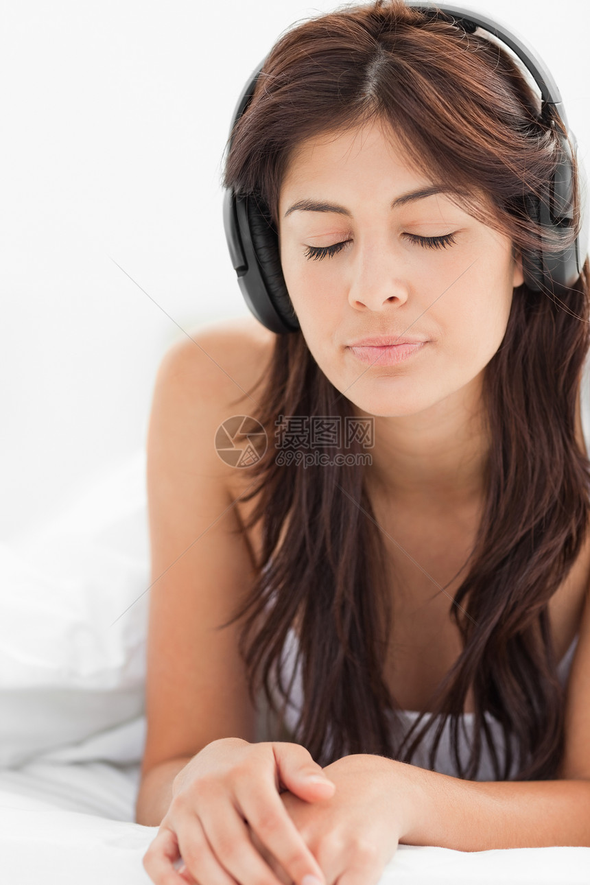 紧闭 女人用眼睛闭着听耳机的声音图片