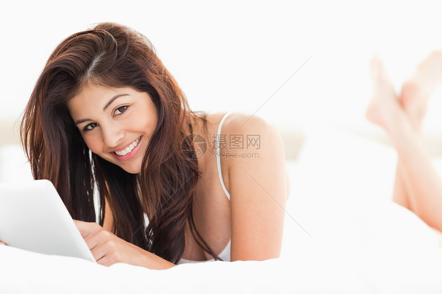 女人拿着一块平板 抬起头笑着看图片