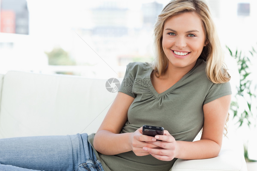 女人在用手机时笑着看着她面前的眼神图片