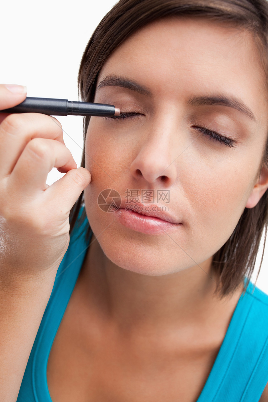 年轻女性用眼笔化妆时使用眼睛铅笔图片