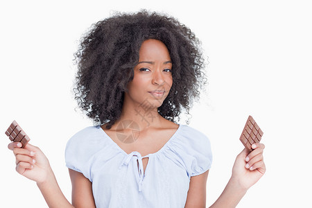 年轻女人拿着两块巧克力的朱古力背景图片