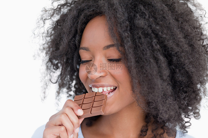年轻女人吃着美味的巧克力棒小妞图片