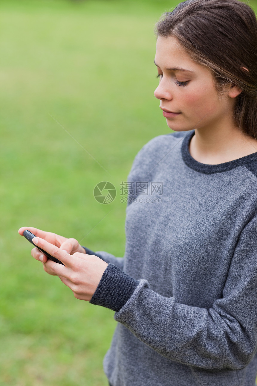 年青严肃的女孩用手机发短信的年轻女孩图片