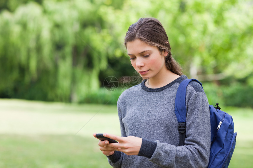 年轻平静的女孩用手机发短信 使用手机发送短信图片