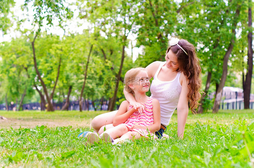 母亲和女儿一起坐在草地上乐趣成人花园场地公园喜悦女性孩子家庭妈妈图片