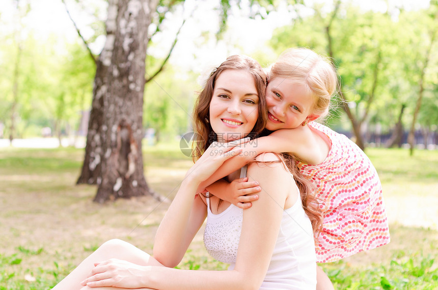 母亲和女儿一起坐在草地上场地女士妈妈花园放松成人乐趣圆圈女性喜悦图片
