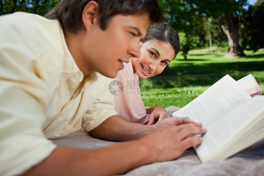 女人在公园里和朋友一起读书时看一看图片