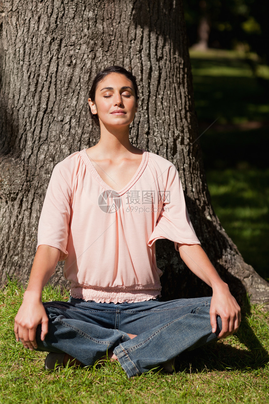 坐在瑜伽姿势中的女人双手跪在膝上图片