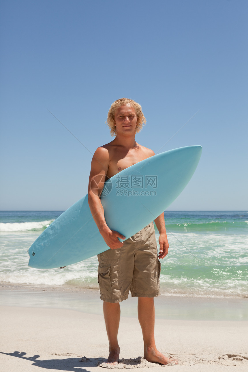 金发人站在海洋前 拿着冲浪板的金发男子图片