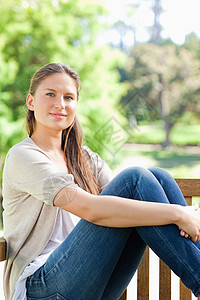 女人在公园的长椅上放松背景图片