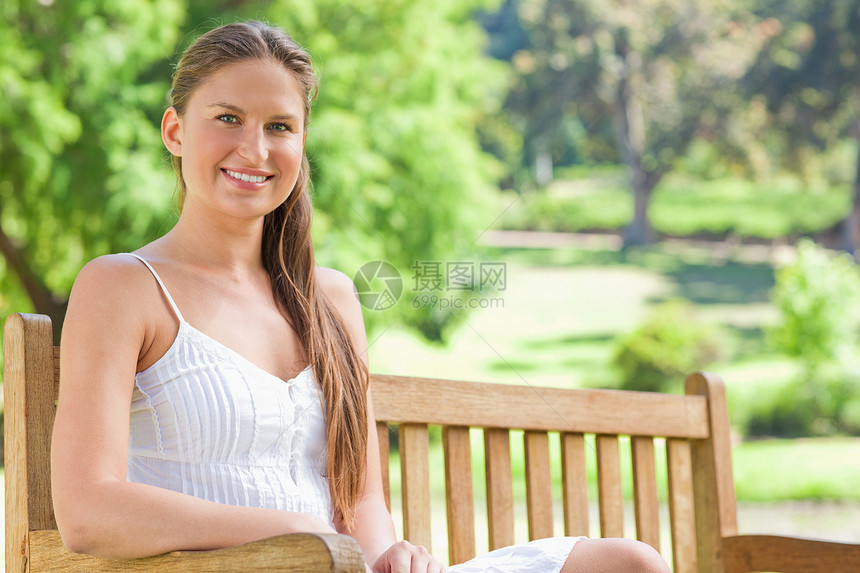 在公园长椅上微笑的女人图片