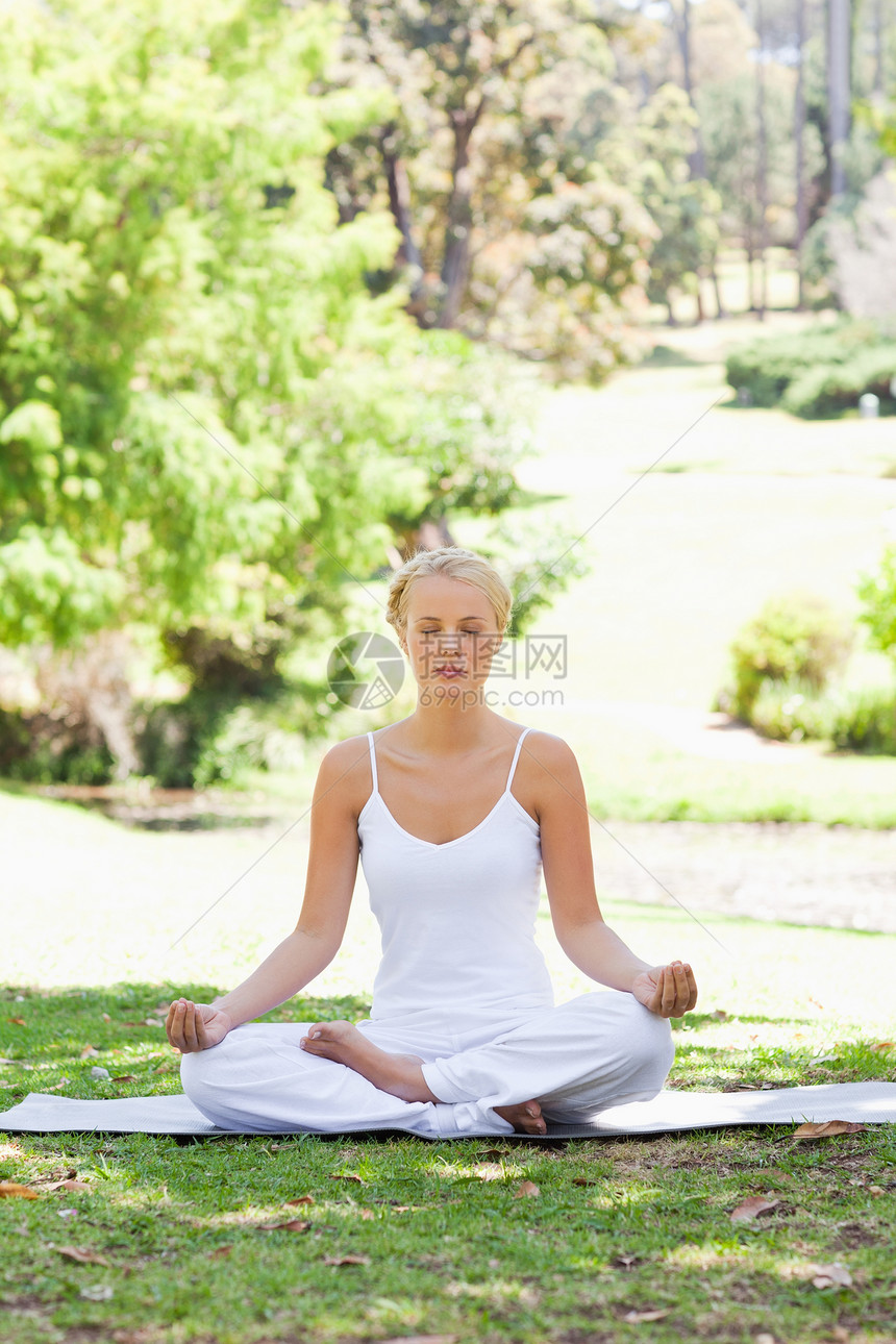 坐在草地上瑜伽姿势的女人图片