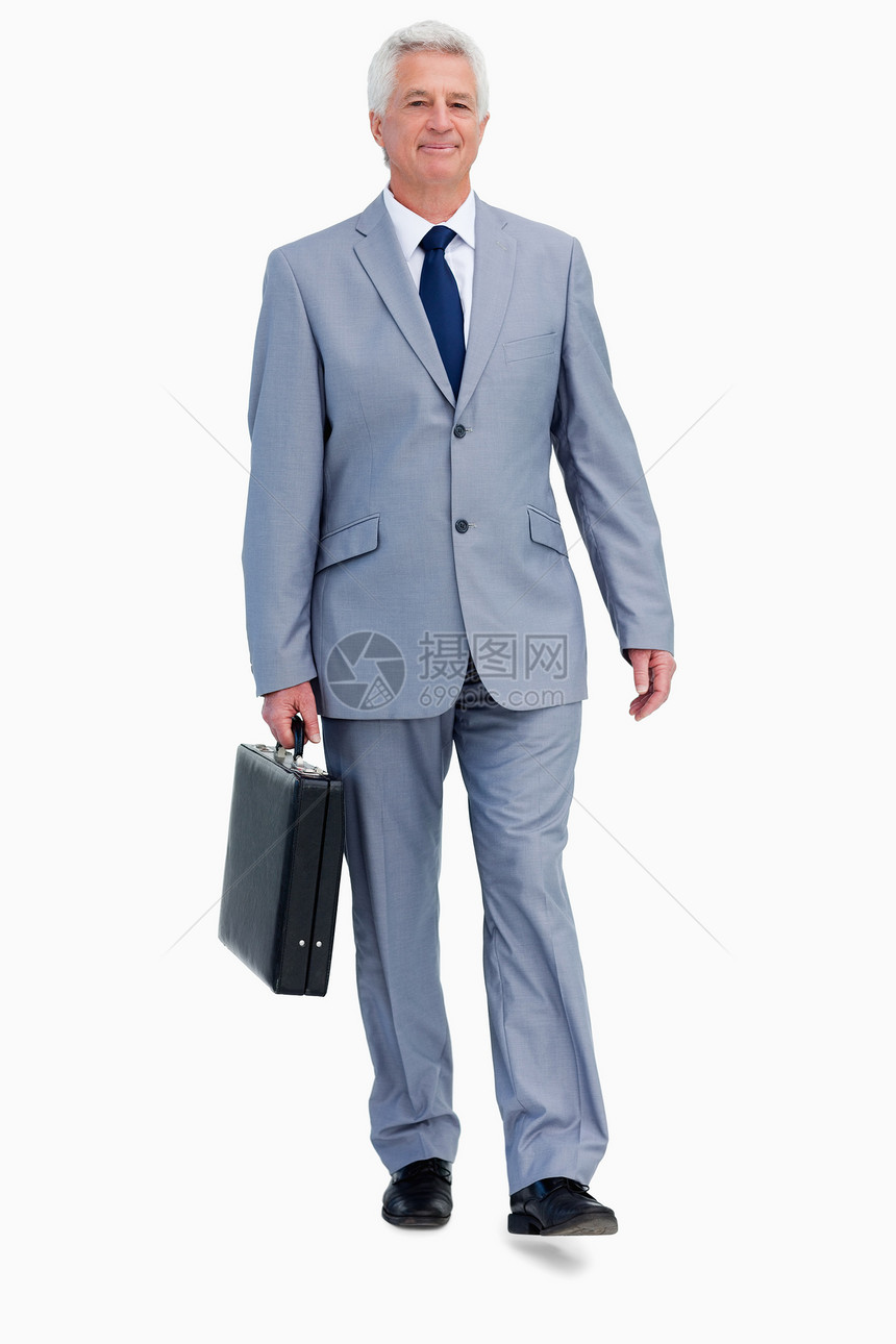一名带着手提箱行走的商务人士的肖像图片