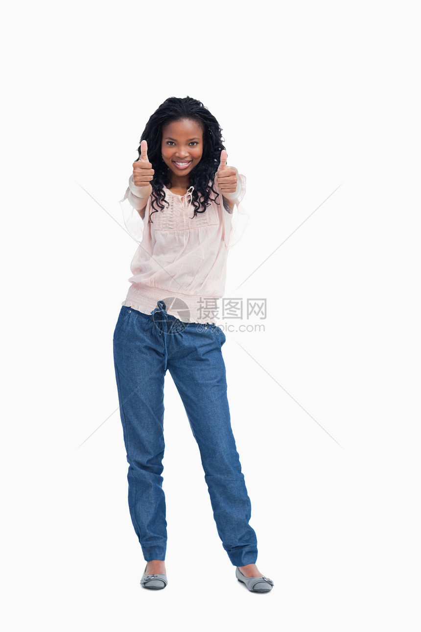 一个微笑的女人站着 举起她的大拇指图片