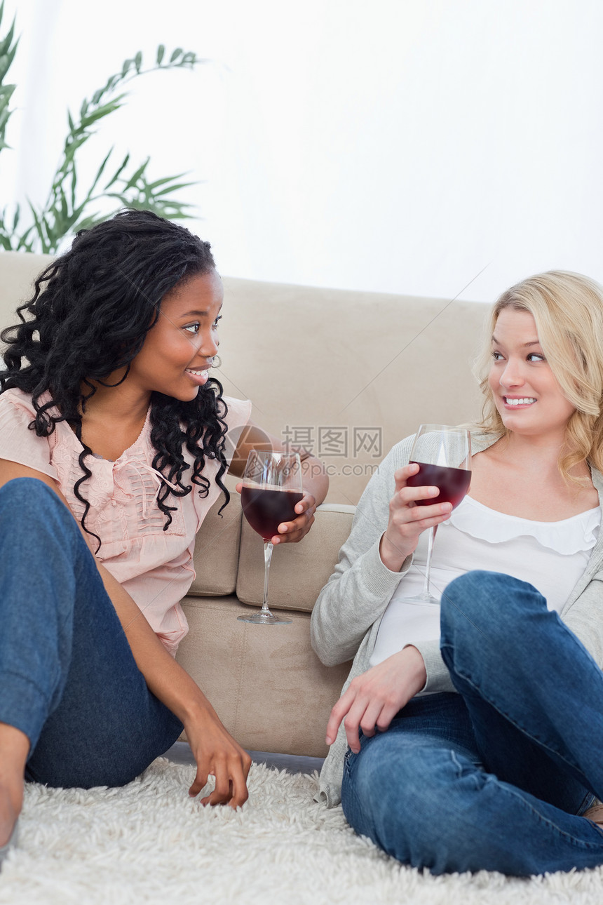 两个女人坐在沙发上 喝着葡萄酒图片