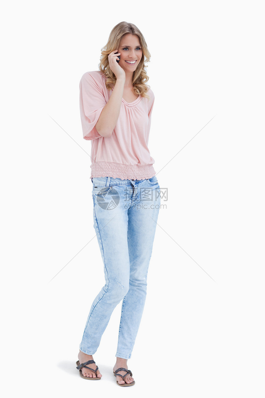 一个微笑的女人 站在她的手机上说着话图片