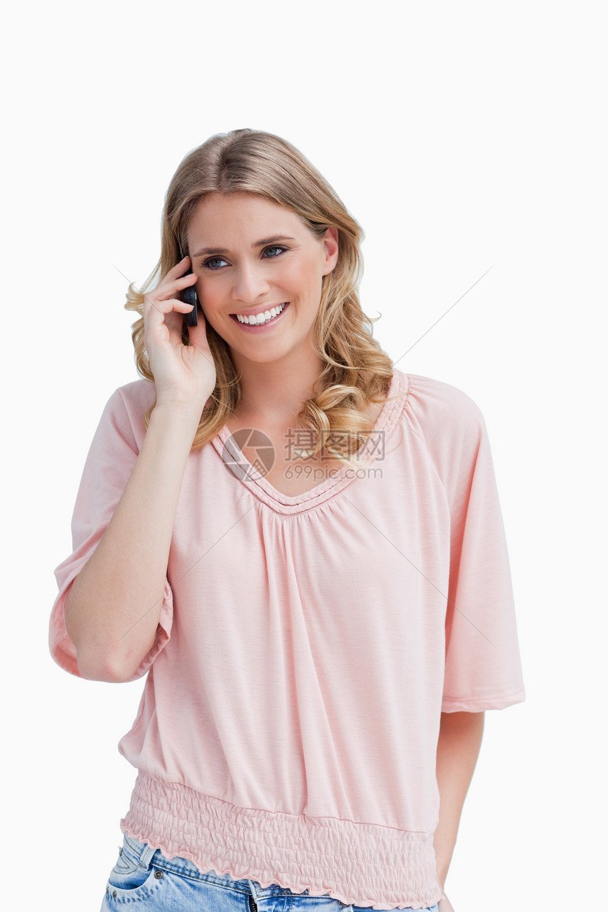微笑的年轻女人在用手机说话图片