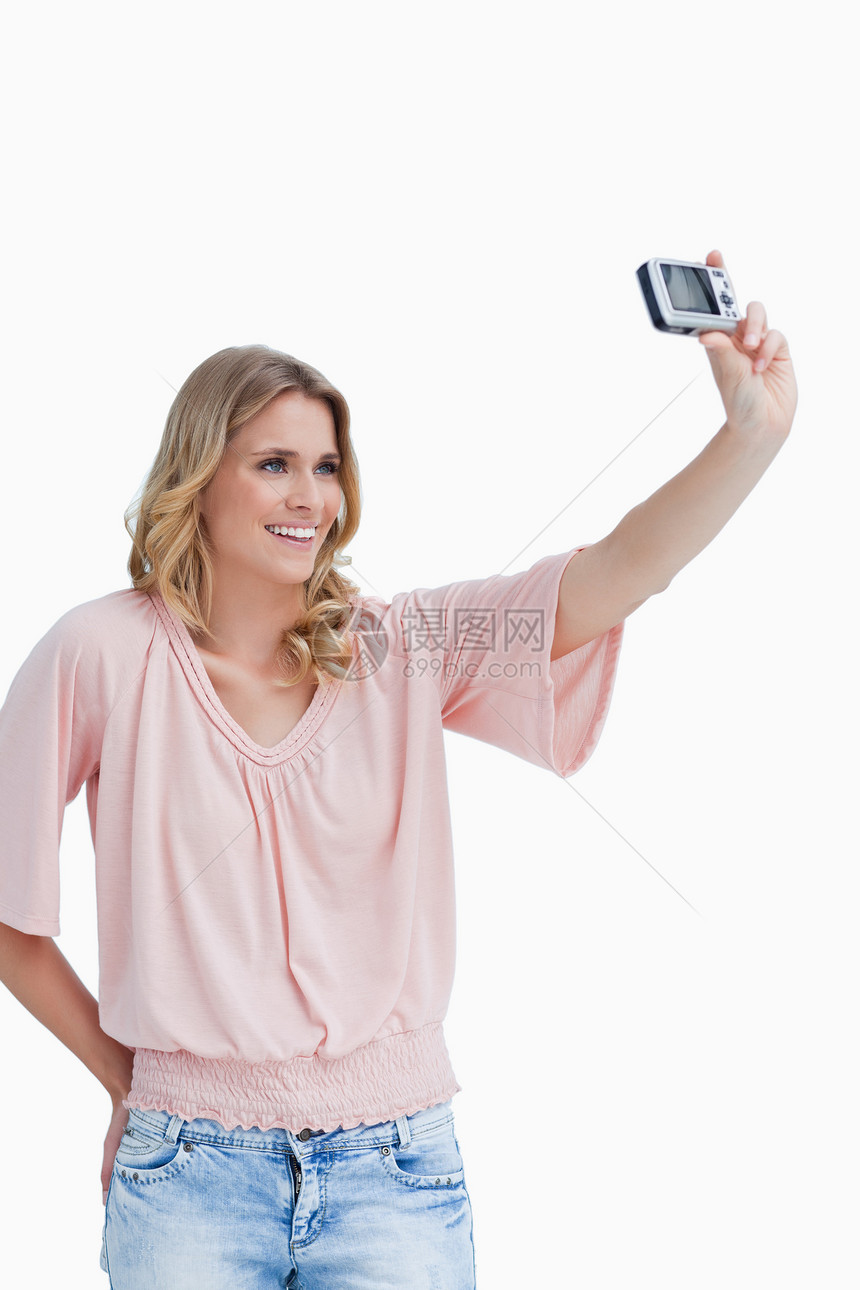 一个女人用照相机在讲自己的照片图片