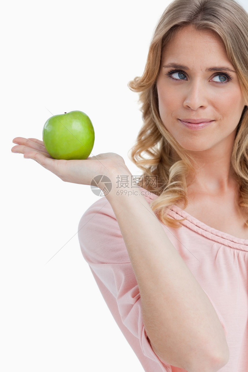 带着绿苹果微笑的年轻女子绿色外表影棚快乐食物金发女郎棕榈水果图片