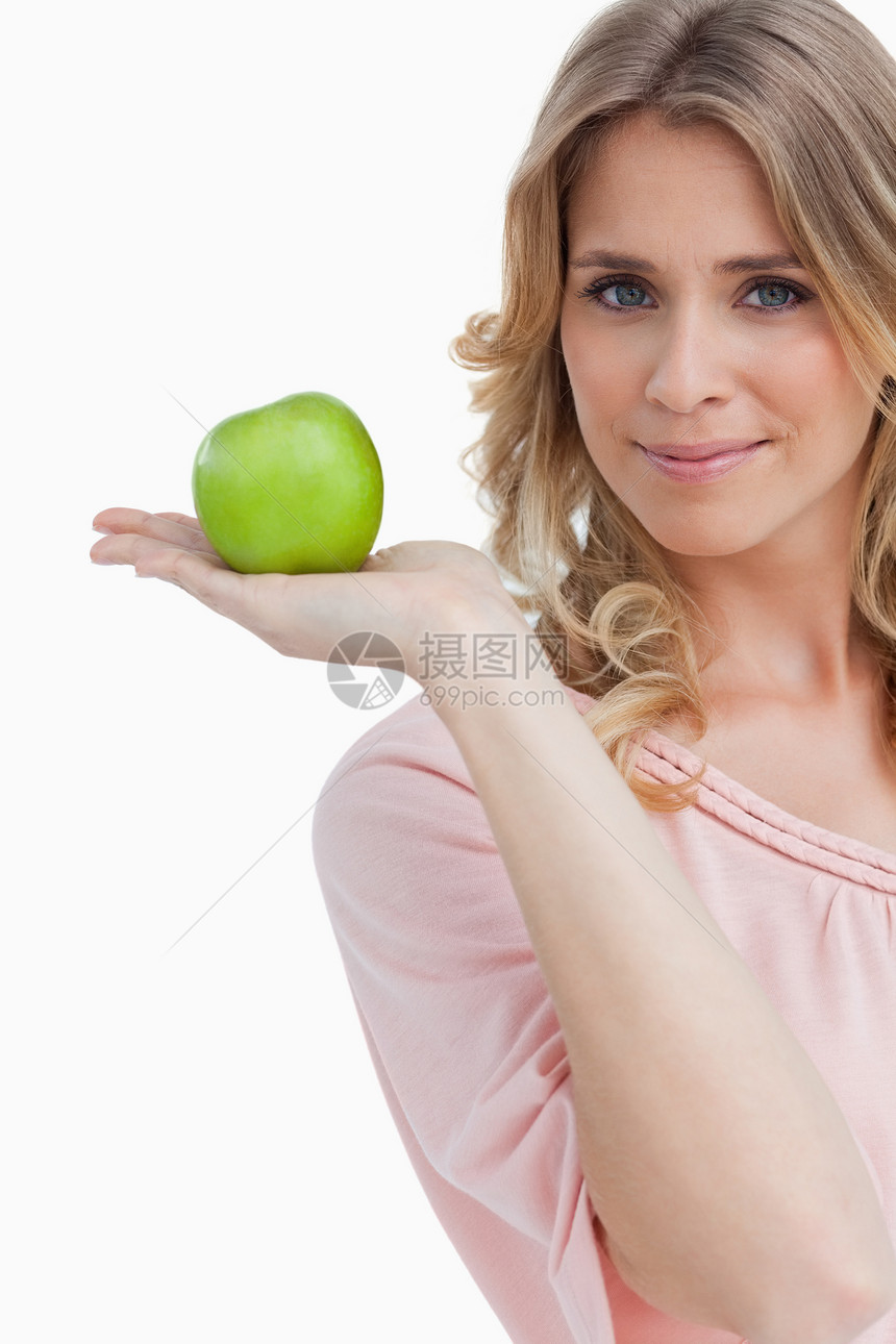年轻女人拿着绿苹果看着相机 看镜头的年青女人图片