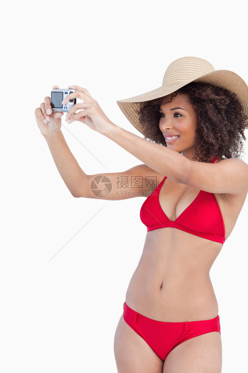 穿着海滩服的年轻女子拍照时图片