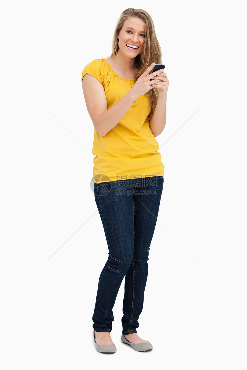 一个金发女人的肖像 使用手机时笑着笑图片