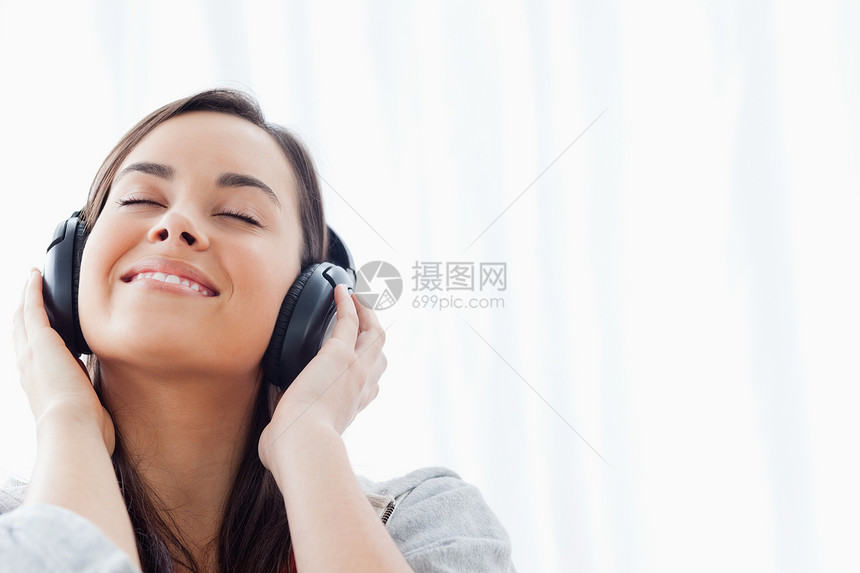 一个笑着听耳机的 女人图片