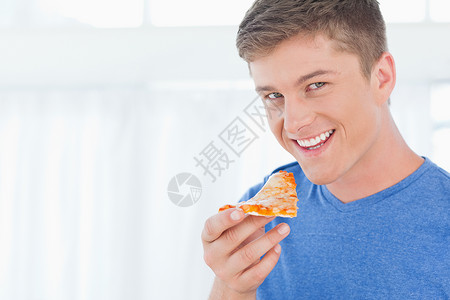 一个拿着披萨的男人 看着摄像机时看到一块比萨饼背景图片