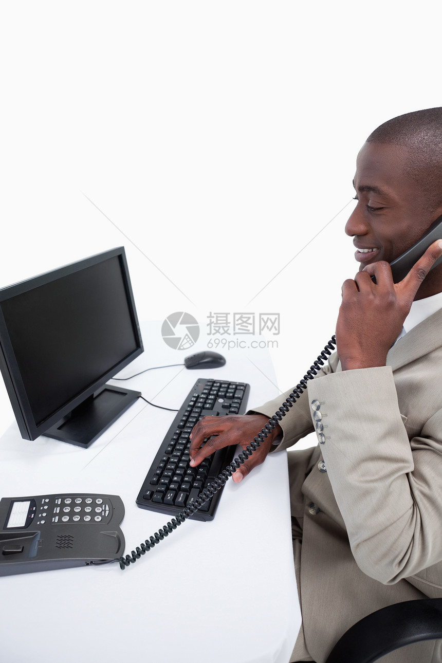 一位男性秘书的侧边视图 他用手机接通了电话职场沟通桌子工人微笑监视器人士经理谈判议员图片