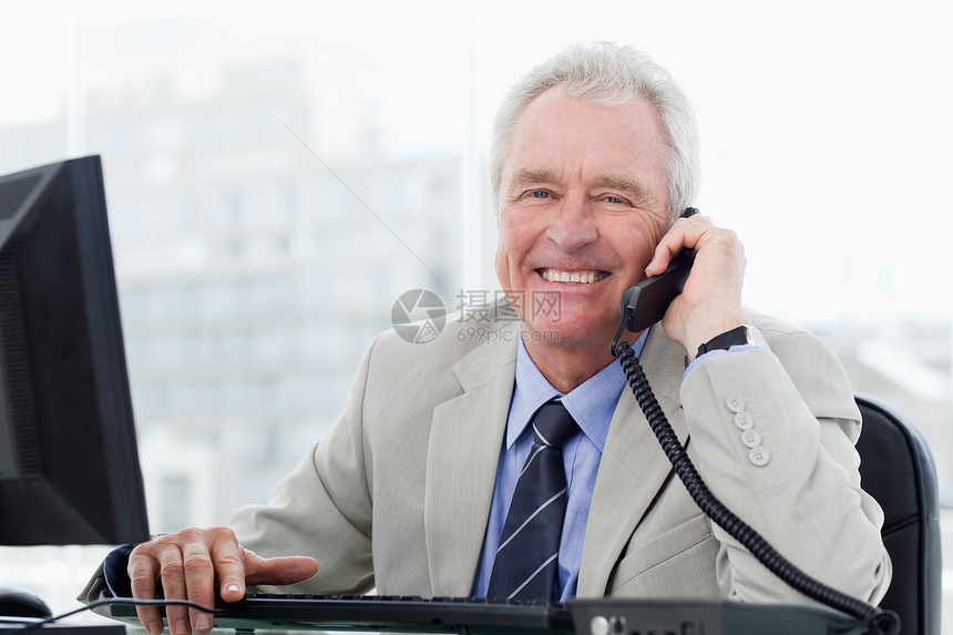 在电话上微笑的高级经理图片