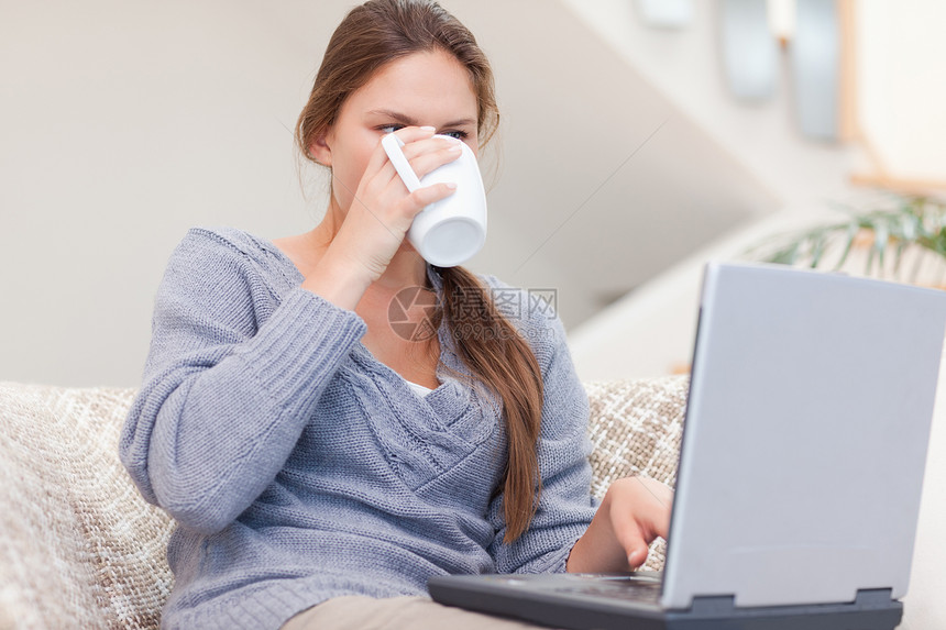 女人在喝杯茶时用笔记本电脑咖啡乐趣网络幸福闲暇沟通饮料快乐微笑沙发图片