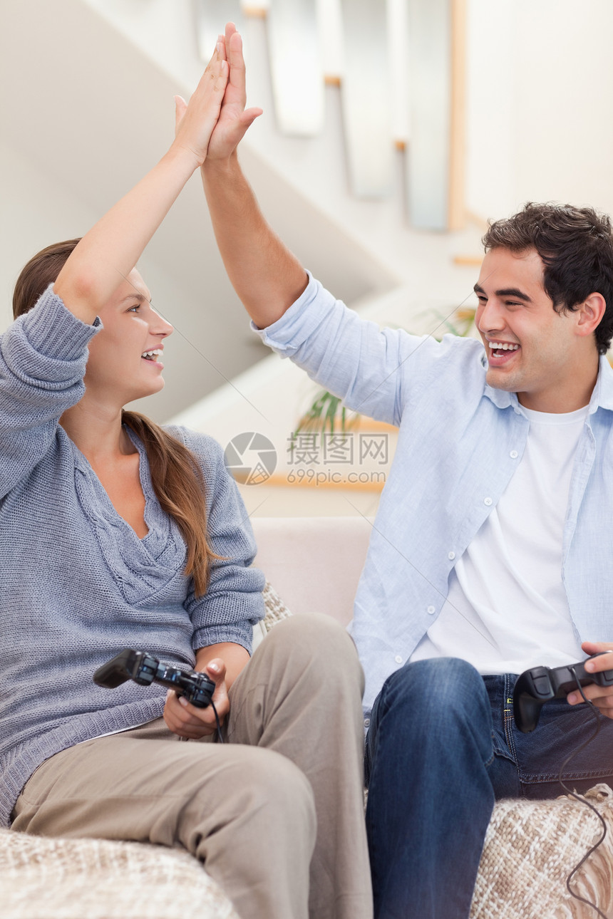 一个快乐的情侣玩电子游戏的肖像图片