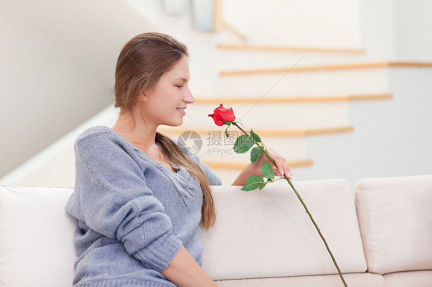 女人闻着玫瑰的气味女性微笑客厅香味沙发长椅香气房子图片