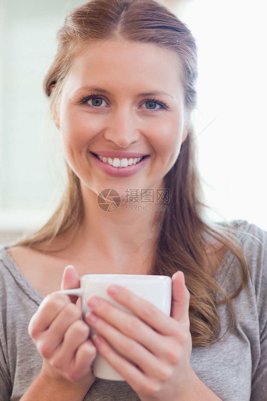 紧贴着微笑的女人 用一杯咖啡图片