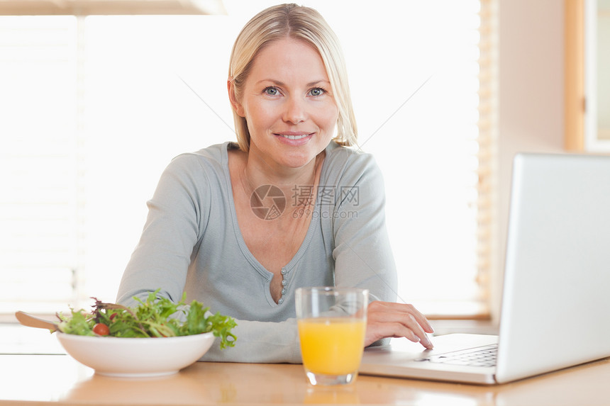 妇女用笔记本工作时有健康午餐图片