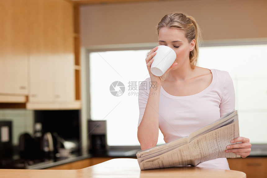 女人在喝咖啡时看新闻图片