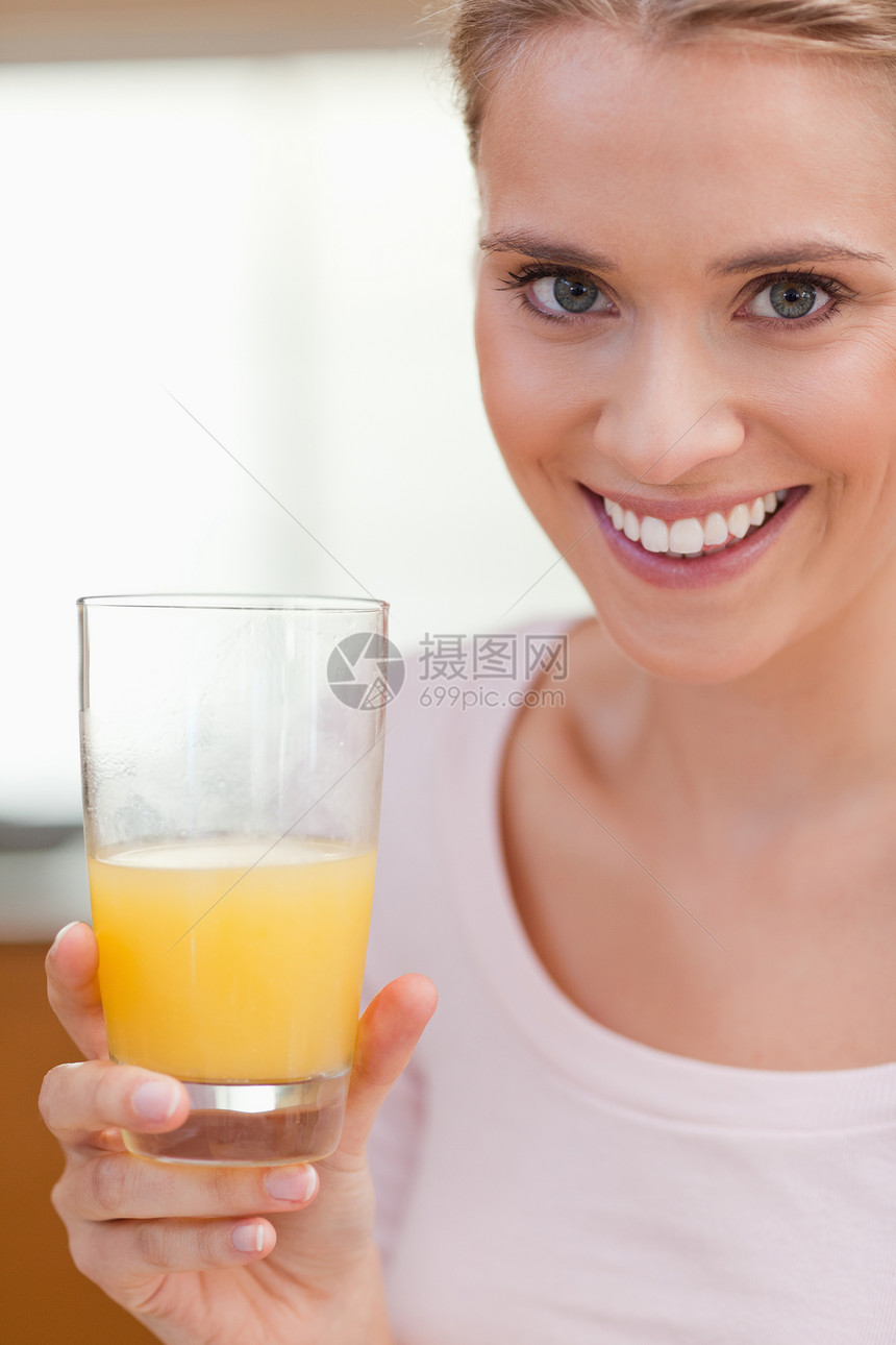 一位喝橙汁的年轻女子的肖像果汁玻璃快乐喜悦乐趣饮料厨房外表活力橙子图片