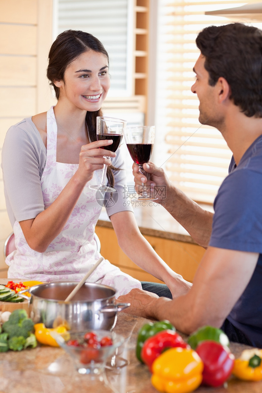 一对夫妇在做饭时喝杯酒的肖像图片